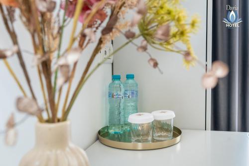 a vase with bottles of water and glasses on a table at Daria Boutique Hotel in Eforie Sud