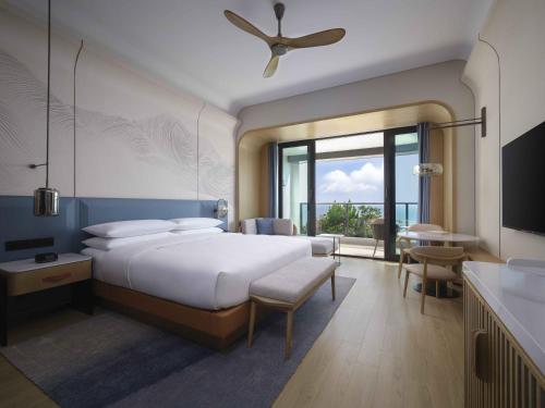 a bedroom with a large bed and a large window at Beihai Marriott Resort in Beihai