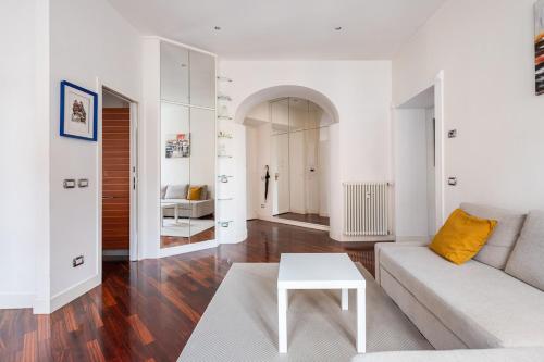 un soggiorno bianco con un divano e un tavolo di La corte di Merlino - Apt centrale di pregio a Roma