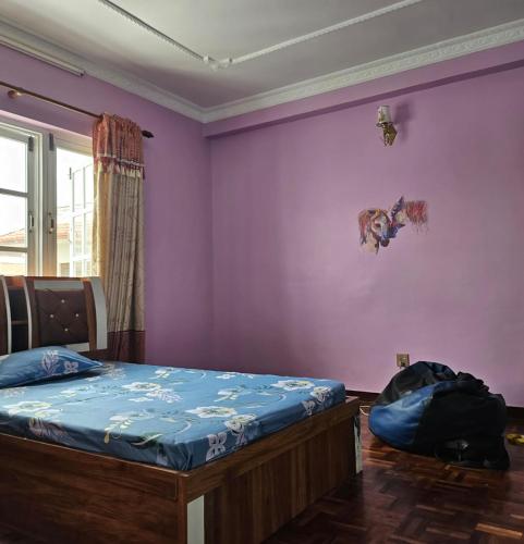 Un dormitorio con una cama y una pared morada. en Bed & Breakfast With Home Theatre, en Tokna