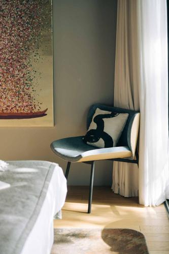 a bedroom with a chair with a bag on it at LOISIUM Wine & Spa Hotel Champagne in Mutigny