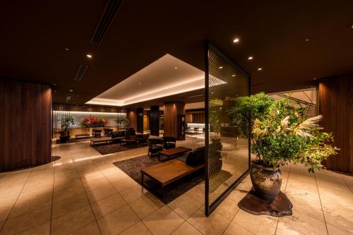 a lobby of a building with plants in it at Kusatsu Estopia Hotel in Kusatsu