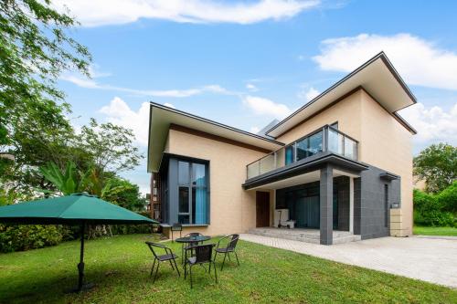 a house with a patio and an umbrella at Forest City Golf Villa by Avery at Johor #Home Party#Located in Golf Resort#Free Parking#中英文房东 in Johor Bahru