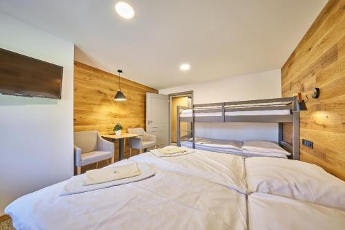 a bedroom with a large white bed and a desk at Hotel Bouda Jana in Pec pod Sněžkou