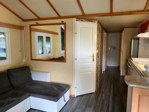 a living room with a couch in a tiny house at Mobil-home 3 chambres in Souvigné