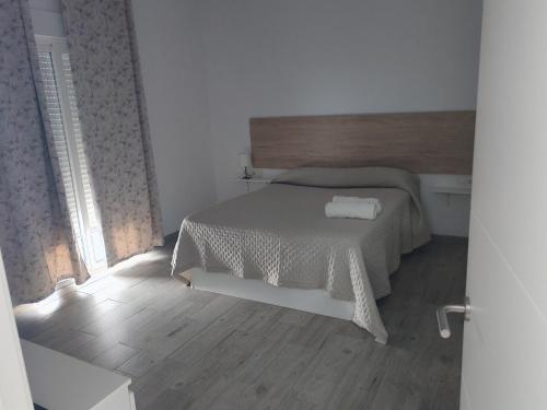 a white bedroom with a bed and a wooden floor at Casa el pinar in La Orotava