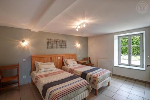 Un dormitorio con dos camas y una ventana. en Aux 3 provinces, en Usson-en-Forez