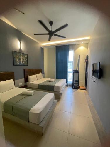 a bedroom with two beds and a ceiling fan at Villa Motel Mas Guesthouse in Batang Berjuntai