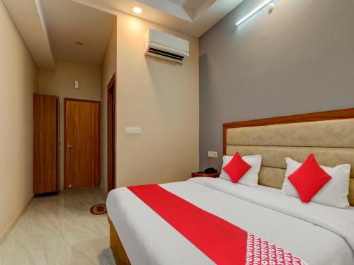 a bedroom with a large bed with red pillows at Hotel O B.S Celebration in Lucknow