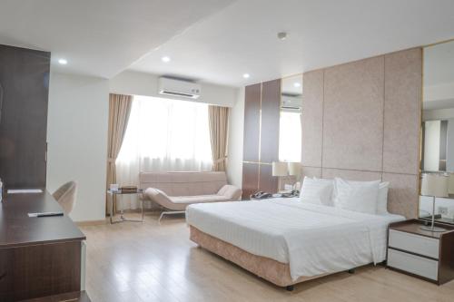a hotel room with a bed and a couch at Bao Son International Hotel in Hanoi