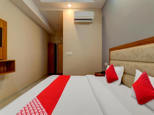 a bedroom with a large bed with red pillows at Hotel O B.S Celebration in Lucknow