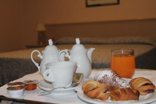a table with a tea set with pastries and a tray of orange juice at Terme Villa Pace in Abano Terme
