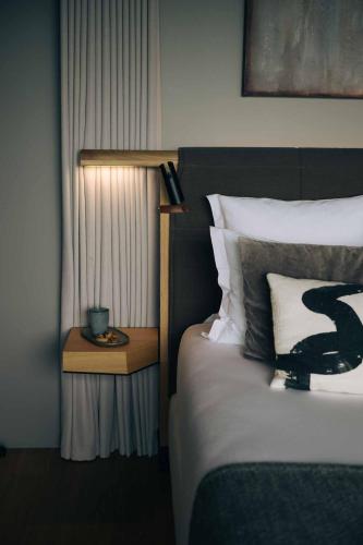 a bedroom with a bed and a nightstand next to a bed sidx sidx sidx at LOISIUM Wine & Spa Hotel Champagne in Mutigny