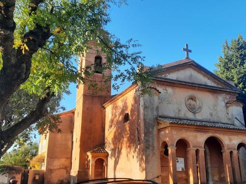 an old church with a tower with a cross on it at Tranquil, calm garden studio with spa pool in Grasse