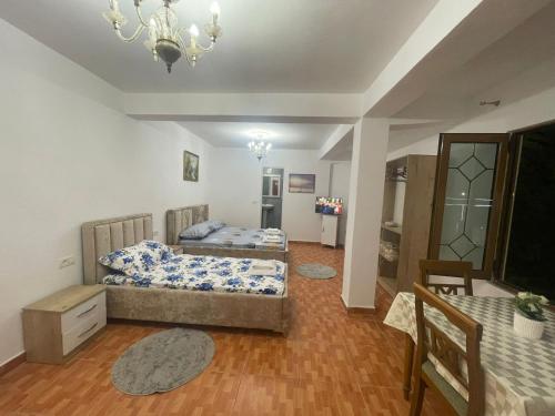 a bedroom with two beds and a table and a chandelier at Guest House Erzeni in Tirana