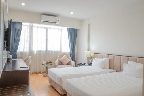 a hotel room with two beds and a window at Bao Son International Hotel in Hanoi