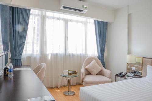 a hotel room with a bed and a desk and a chair at Bao Son International Hotel in Hanoi
