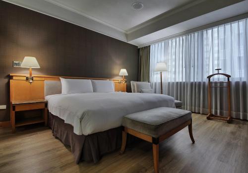 a bedroom with a large bed and a large window at The Carlton Hotel Hsinchu in Hsinchu City