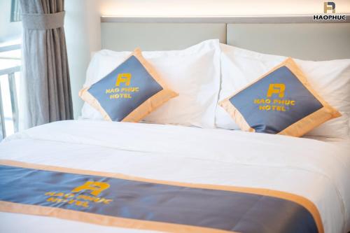 a bed with two pillows with a no wake zone sign on it at Hào Phúc Hotel 