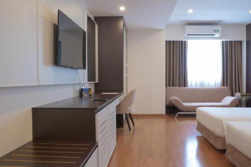 a hotel room with a bed and a living room at Bao Son International Hotel in Hanoi
