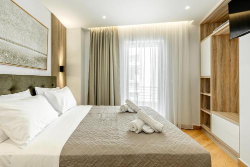 a bedroom with a large bed with towels on it at Magea Suites in Áyios Andónios