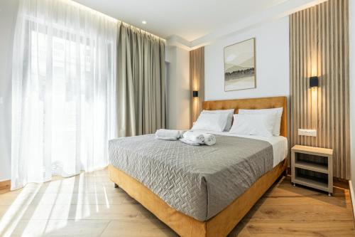 a bedroom with a bed with two towels on it at Magea Suites in Áyios Andónios