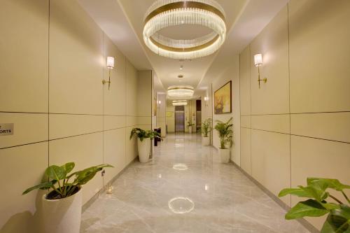 a hallway with potted plants and a large chandelier at Cygnett Inn in Dibrugarh
