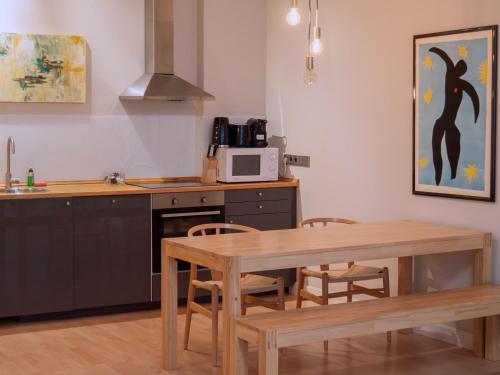 a kitchen with a wooden table and a microwave at Living am Carlsplatz Apartment in Düsseldorf