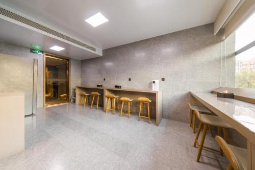 a lobby with a bar with stools at JI Hotel Beijing Zhongguancun Suzhou Street in Beijing