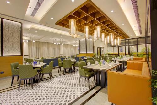 a dining room with tables and chairs and chandeliers at Cygnett Inn in Dibrugarh