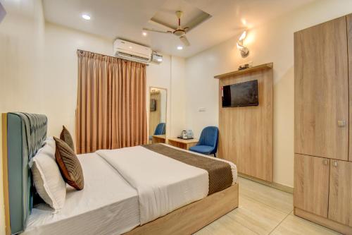 a bedroom with a bed and a tv and a desk at Le Mysuru Palace in Mysore