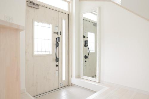 a bathroom with a door and a mirror at 静岡 伊豆高原 ペットと泊まれるプライベートヴィラ Tous les doudouトゥレ ドゥドゥ in Ito