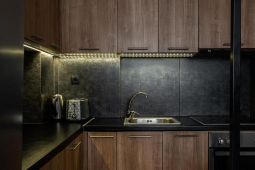 a kitchen with a sink and wooden cabinets at The Gate by Zoia Living in Athens