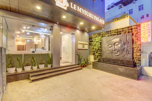 a store front with a statue of a face on the wall at Le Mysuru Palace in Mysore