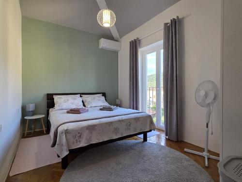 a bedroom with a bed and a window with a fan at The Lovely Loft in Cres