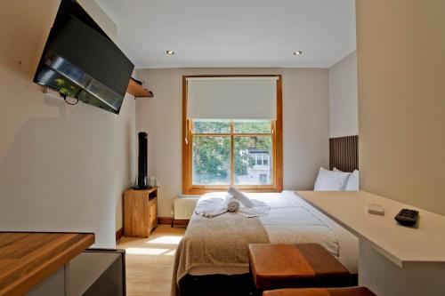 a hotel room with a bed and a window at Imperial Earls Court Apartments in London