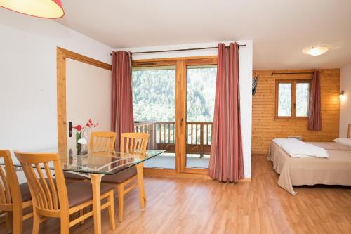 a room with a dining table and a bedroom at Hameau 8 201 - SPA & PISCINE studio 4 pers in Orelle
