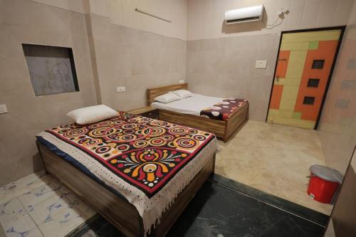 a room with two beds in a room at Kalindi Blessings Deluxe Guest House in Mathura