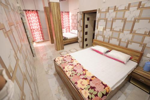 a bedroom with a bed in a room with a mirror at Kalindi Blessings Deluxe Guest House in Mathura