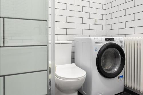 a bathroom with a toilet and a washing machine at The Gate by Zoia Living in Athens