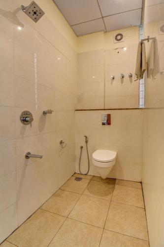 a bathroom with a toilet and a shower at Le Mysuru Palace in Mysore
