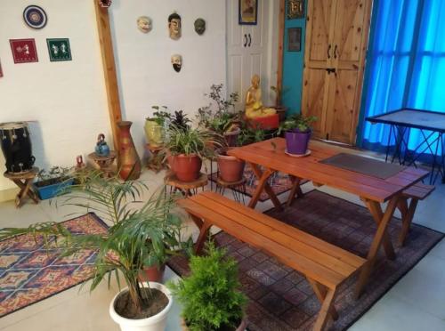 Habitación con mesa de madera y macetas. en Rumis Mountain Sunset, en Nainital