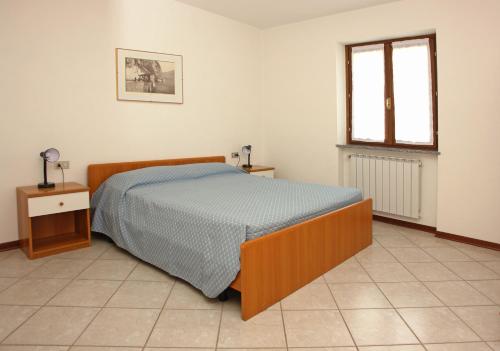 a bedroom with a bed and a window at Residence Ruculì - Ruculì Hospitality in Tignale