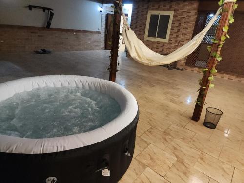 a large hot tub in a room with a hammock at Private rooftop with jacuzzi and pyramids view in ‘Ezbet `Abd el-Ḥamîd