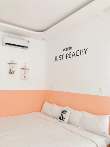 a bedroom with a bed and a sign that reads just peachy at The Chill in Hue