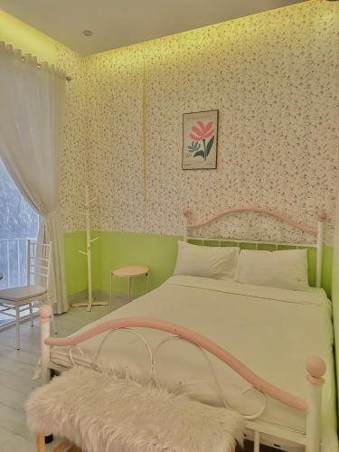 a bedroom with a white bed with a pink frame at The Chill in Hue