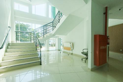 a hallway with stairs and a chair in a building at Urbanview Hotel Syariah UIN Mataram in Mataram