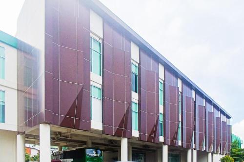 a large building with a purple facade at Urbanview Hotel Syariah UIN Mataram in Mataram