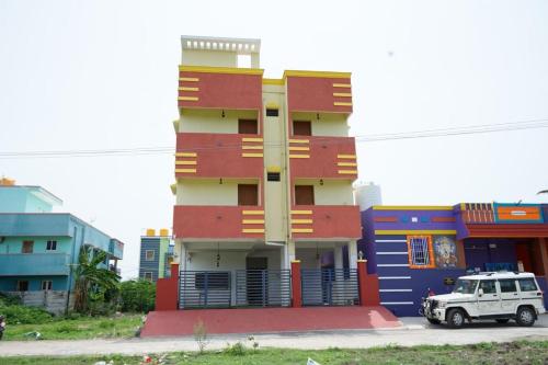 a colorful building with a car parked in front of it at Siesta Inn - RP Resort in Chennai