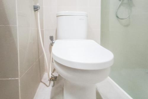 a white toilet in a bathroom with a shower at Urbanview Hotel Syariah UIN Mataram in Mataram